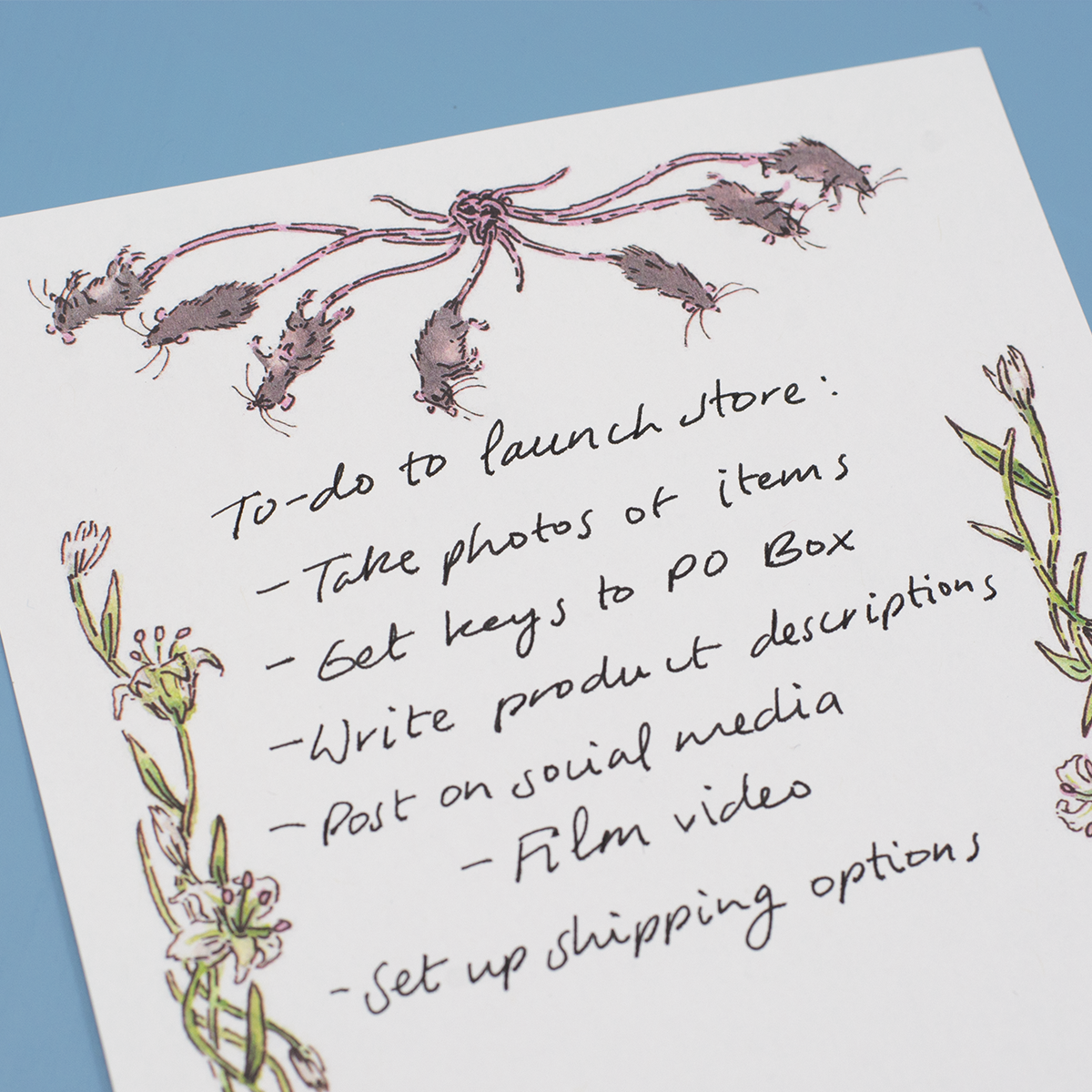 Close up detail of a page from the "Rat King Tearaway Notepad". The list handwritten on the page reads "To-do to launch store: take photos of items, get keys to PO box, write product descriptions, post on social media (film video), set up shipping options".